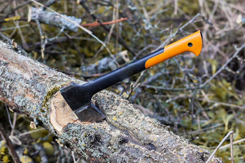 A hatchet partially chopping a log