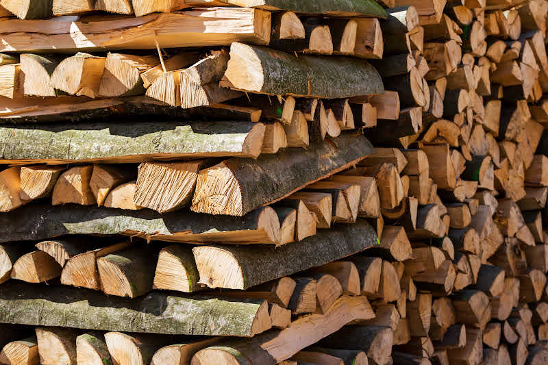 A closeup of criss cross stacked split logs