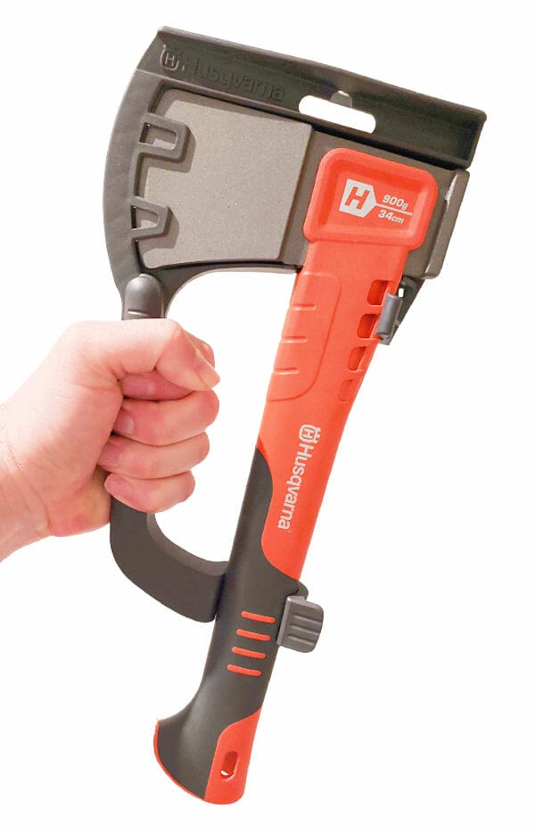 A hand holding the Husqvarna H900 by its handle which is part of the sheath