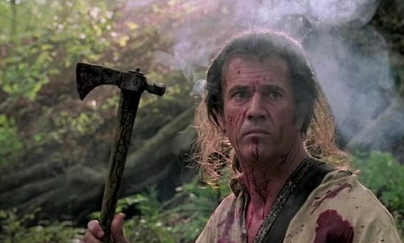 A screenshot from the movie 'The Patriot' showing Mel Gibson holding a hatchet as a weapon